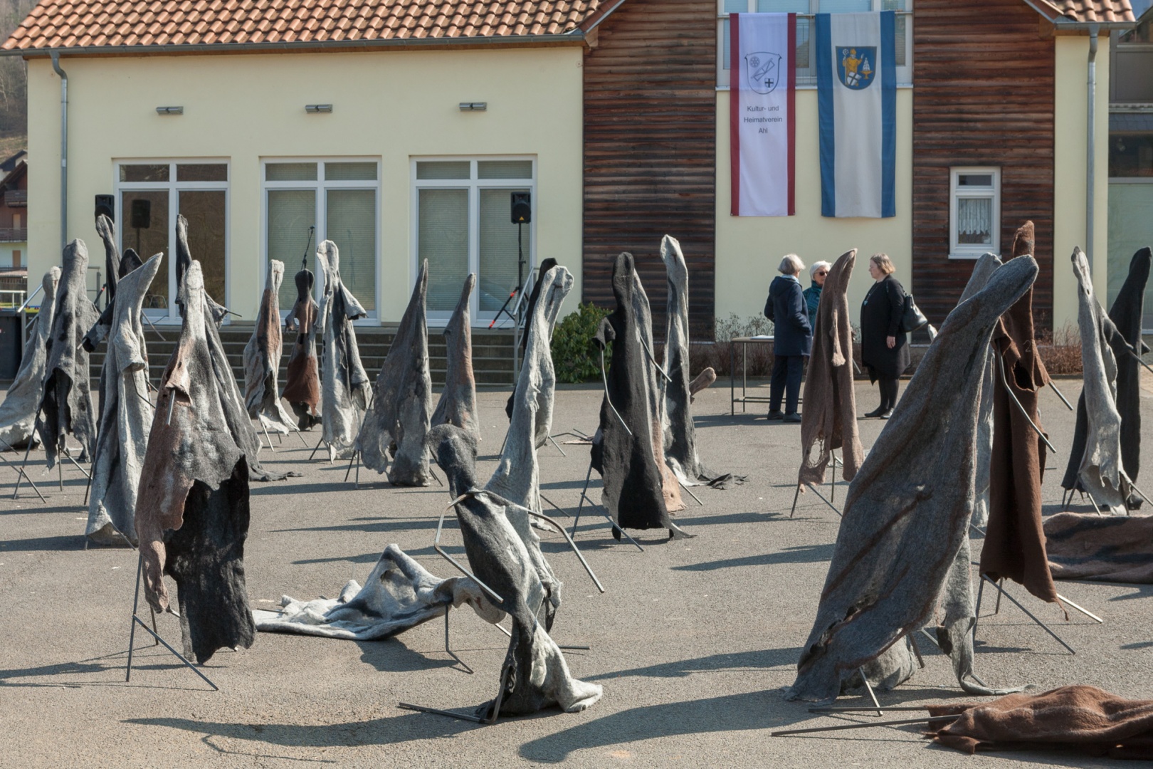 Gestalten des Jammers vor dem Dorfgemeinschaftshaus