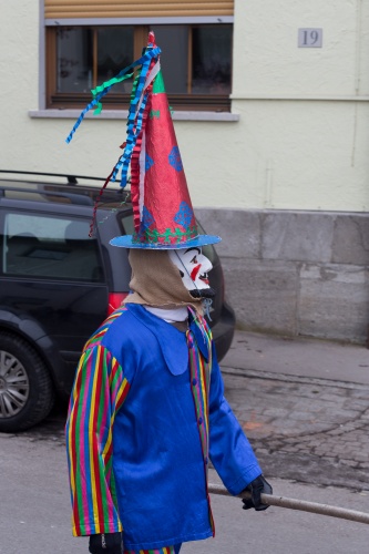 Maske mit Spitzhut und blauem Kittel