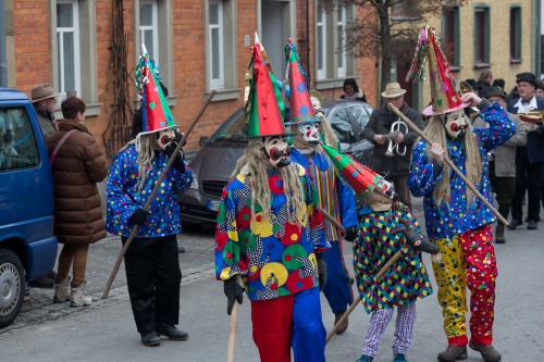 Maske mit Spitzhut und bunten Kitteln