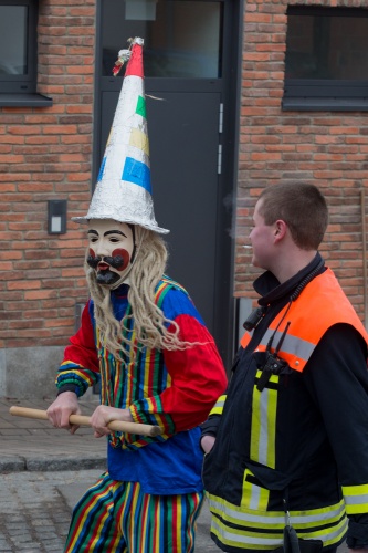 Maske mit Spitzhut und gestreiftem Kittel - bedraengter Feuerwehrmann